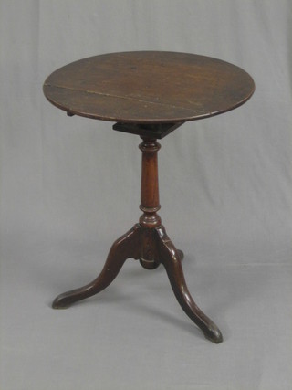 An 18th Century circular oak wine table with bird cage action, raised on pillar and tripod supports (some old worm) 22"