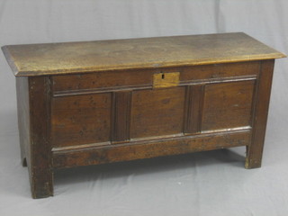 A 17th/18th Century oak coffer of panelled construction with hinged lid, the interior fitted a candle box (patch to front) 46"