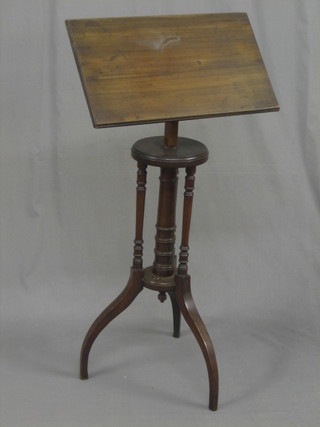 A 19th Century mahogany adjustable reading stand, raised on a turned column base supported by 3 further columns and raised on scrolled feet 21"