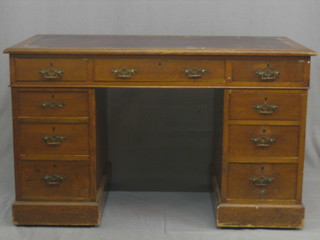 A Victorian honey oak desk with inset tooled leather writing surface above 9 long drawers 49"
