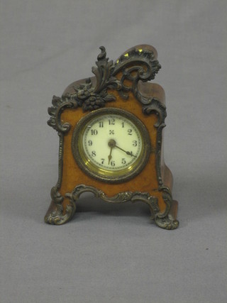 A Continental bedroom timepiece contained in a walnut and gilt metal embossed case