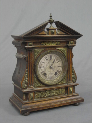 A 19th Century Continental 8 day striking bracket clock with silvered dial and Roman numerals contained in an oak and gilt metal embellished case