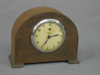 A 1930's electric mantel clock by TMCO with paper dial and Arabic numerals contained in an oak arch shaped case