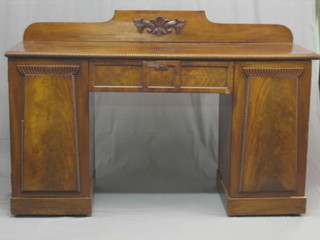 A Regency mahogany  pedestal drop sideboard with carved back and gadrooned borders, fitted 1 drawer flanked by a pair of cupboards enclosed by panelled doors 67"