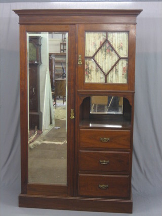 An Edwardian walnut wardrobe with moulded cornice, enclosed by a rectangular bevelled plate mirrored door to one side, the other fitted a cupboard enclosed by a bevelled plate glazed panelled door above a recess, the base fitted 3 long drawers and raised on a platform base 51"