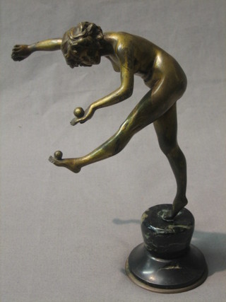 An Art Deco figure of a standing figure balancing 3 balls, raised on a marble base 7"