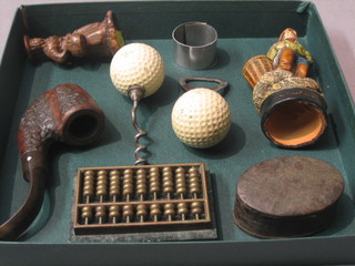 A novelty golf ball bottle opener and corkscrew, a carved pipe, an Eastern bronze and marble abacus, a pair of early goggles, cased, a pottery figure of a fisherman and 1 other pottery figure