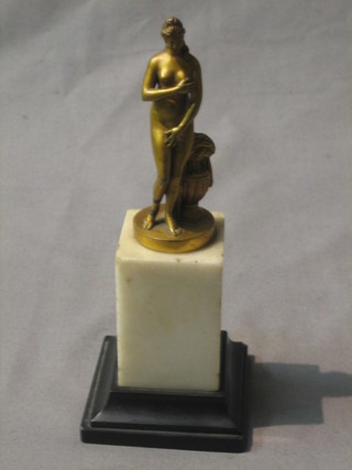 A gilt bronze figure of a Venus standing by an urn, raised on a black and white square marble base  6" 