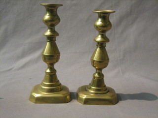 A pair of brass candlesticks with ejectors