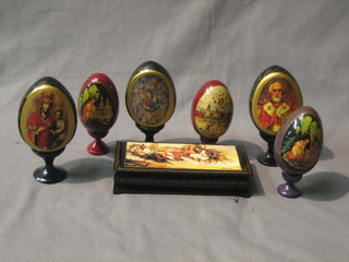 A modern rectangular Russian lacquered box with hinged lid 6 1/2" together with 6 modern Russian lacquered eggs decorated religious scenes