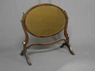A 19th Century oval plate dressing table mirror contained in a mahogany swing frame