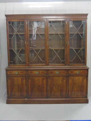 A Georgian style mahogany bookcase on cabinet, the upper section with moulded and dentil cornice, the interior fitted adjustable shelves enclosed by astragal glazed doors, the base fitted 4 drawers above 4 double cupboards, raised on a platform base 70"