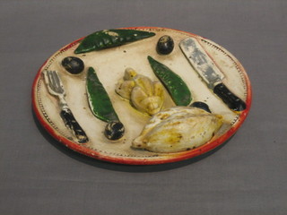 A 1920's Continental pottery plate decorated a roast chicken, mange tout, knife and fork 9"