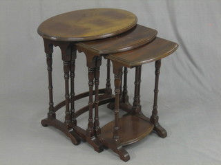 A nest of 3 oval mahogany interfitting coffee tables, raised on turned supports 24"