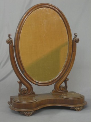 A Victorian oval bevelled plate dressing table mirror contained in a mahogany swing frame, the base of serpentine outline fitted 2 circular jewellery boxes 21"