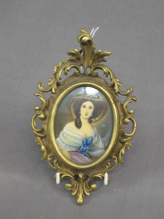 A 19th/20th Century portrait miniature of a seated bonnetted lady, monogrammed ET, contained in a decorative gilt frame 4" oval