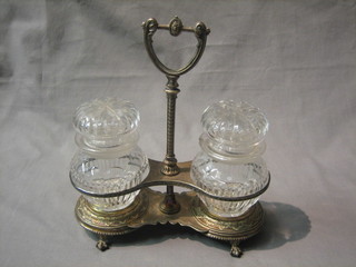 A silver plated 2 bottle pickle stand with 2 cut glass jars and covers (1 with lid f)