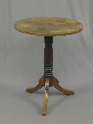 A 19th Century elm and mahogany circular wine table, raised on a carved column and tripod supports 22" (split to top)