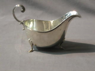 A silver Georgian style sauce boat with C scroll handle, raised on 3 spade feet, Sheffield 1930, by Walker & Hall, 4 ozs