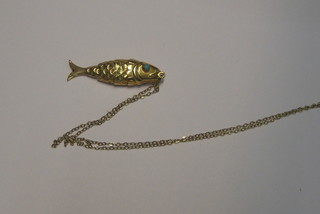 A 9ct gold pendant in the form of an articulated fish, the eyes set turquoise and hung on a gold chain