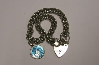 A silver curb link charm bracelet hung a charm and with padlock clasp
