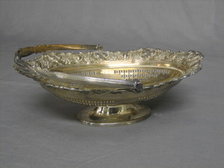 A boat shaped pierced silver plated cake basket with swing handle, raised on an oval foot