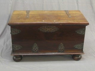 A camphor wood coffer with brass banding and hinges, raised on bun feet 37"