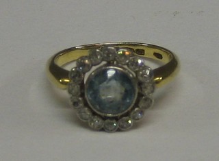 A lady's 18ct gold dress ring set an aquamarine surrounded by numerous diamonds