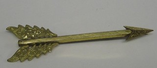 A gilt metal arrow brooch