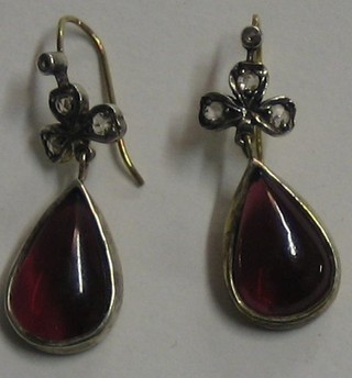 A pair of lady's cabouchon cut garnet tear drop earrings surmounted by diamonds