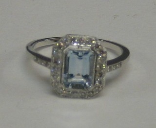 A lady's 18ct white gold dress ring set a rectangular cut aquamarine surrounded by numerous diamonds