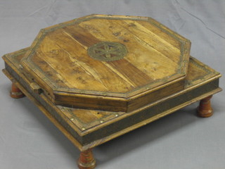 An Eastern hardwood and brass decorated table with hinged lid, raised on turned supports 24"