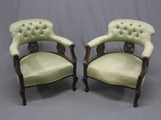A pair of Edwardian mahogany tub back dining chairs upholstered in green material