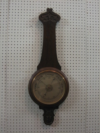A wheel barometer contained in an oak case