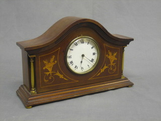 A 19th Century French mantel clock with enamelled dial and Roman numerals contained in an arch shaped inlaid mahogany case supported by brass columns