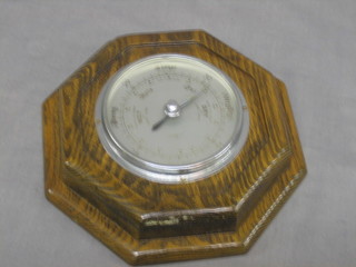 An Art Deco aneroid barometer with silvered dial contained in an oak octagonal case 8"