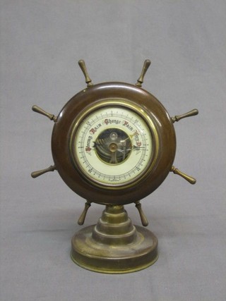 A German aneroid barometer with paper dial contained in a circular mahogany case in the form of a ships wheel