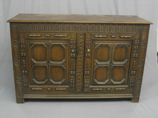 A Continental oak sideboard enclosed by carved and panelled doors, raised on square feet 59"