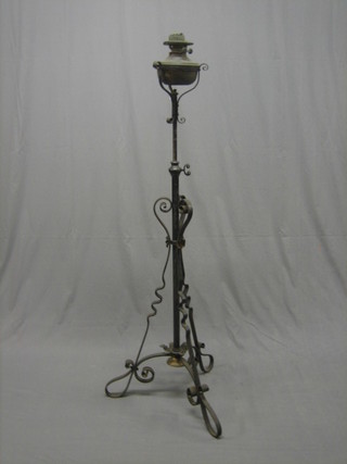 A 19th Century copper oil lamp raised on a wrought iron adjustable stand