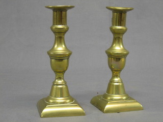 A pair of 19th Century bronze candlesticks with ejectors, raised on square bases 8"