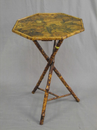 An octagonal bamboo occasional table the top decorated various scraps 17"
