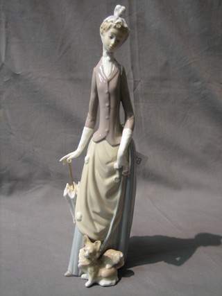A Lladro figure of a standing lady with parasol and dog, base incised 4M 14"