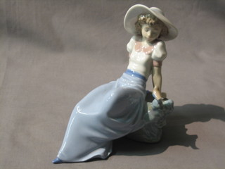A Nao figure of a reclining girl with bird 8"