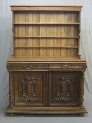 A 19th Century carved oak French dresser base, fitted 2 long drawers above a pair of cupboards enclosed by panelled doors, raised on a turned column, together with an associated later raised back fitted shelves 56"