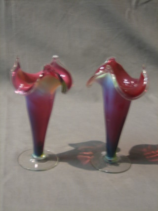 A pair of cranberry glass flared vases, raised on circular feet 6"