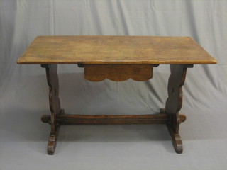 A 1930's rectangular oak refectory style dining table, raised on pierced standard end supports with H framed stretcher 49"