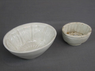 An oval white glazed jelly mould 2 1/2" and 1 other 5"