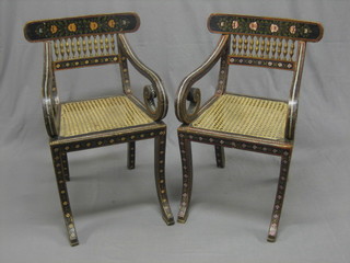 A pair of Regency style Continental painted bar back open arm carver chairs with woven rush seats, raised on sabre supports