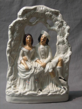 A 19th Century Staffordshire flat back figure of a seated Scotsman and lady 13"