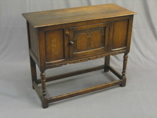 A 17th Century style oak Hutch cabinet fitted a cupboard with arcaded decoration raised on turned and block supports 35"